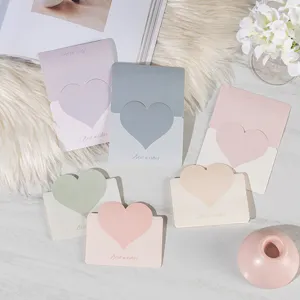 Nahaufnahme von 3D-Herz-Grußkarten in Morandi-Farben mit goldener Best-Wishes-Prägung.