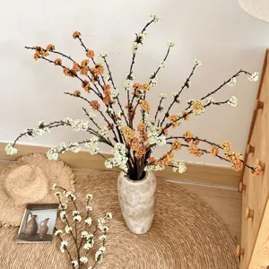 Ramas de bayas de espuma artificial en un jarrón para una decoración de hogar cálida