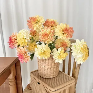 Detailed view of 3-headed artificial dahlia flowers in a woven basket for home decor.