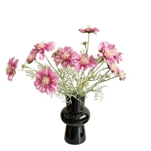 Elegante künstliche Skabiosen in leuchtendem Rosa mit einer schicken schwarzen Ziervase