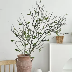 Realistic artificial dry branches with green buds in a rustic terracotta vase for home decor