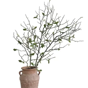 Lifelike artificial dry branches with green leaf buds in a rustic terracotta flower vase.