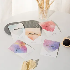 Group of colorful heart-shaped watercolor greeting cards with Best wishes text on a white table