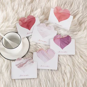 Close-up of elegant marble pattern heart greeting cards on a white plush background