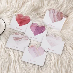 Macro view of heart-shaped marble greeting cards displayed on a soft white fur background