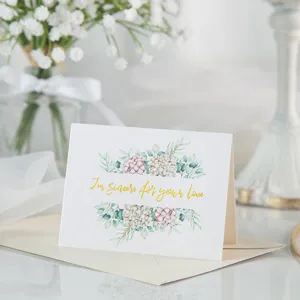 Detalle de una elegante tarjeta de felicitación con pan de oro y motivos florales finos