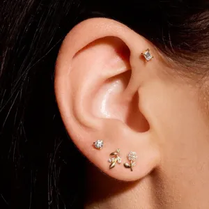 Close-up of elegant flower and leaf zircon ear studs worn on ear lobe and cartilage
