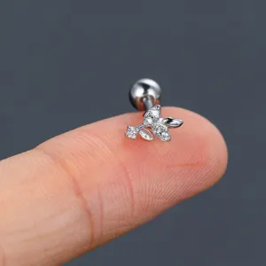 Detailed macro view of silver flower cartilage stud with zircon inlay on finger