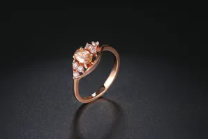Vista detallada del anillo bañado en oro rosa con piedra ovalada amarilla y cristales.