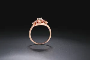 Detalle de anillo bañado en oro rosa con diseño de racimo de piedra amarilla y gemas.