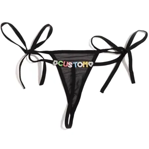Tanga transparente de encaje negro con tiras laterales y letras personalizadas de pedrería.