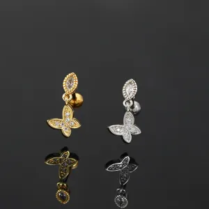 Detailed macro shot of elegant gold and silver butterfly zircon cartilage earrings