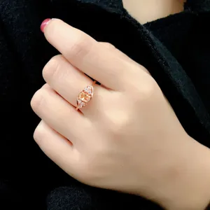 Detalle de primer plano de un anillo chapado en oro rosa con piedra amarilla y circonitas.