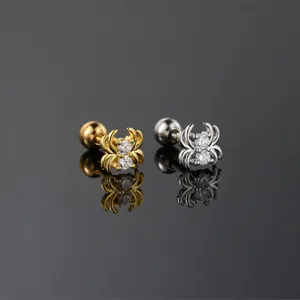 Macro detail of gold and silver spider-shaped screw back earrings with clear zircons