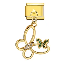 Macro detail of a golden butterfly Italian charm with inlaid green and white zircon stones