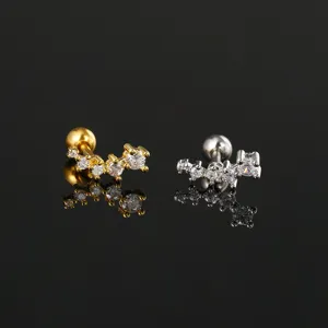 Detail van geometrische zirkoon oorknopjes met gouden en zilveren schroefsluiting.