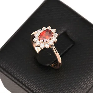 Elegant rose gold plated ring featuring a large red oval zircon surrounded by crystals.