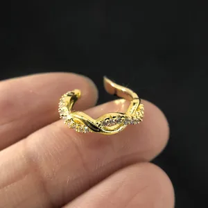 Nahaufnahme einer vergoldeten gedrehten Ohrklemme mit Zirkonien für Ohren ohne Piercing.