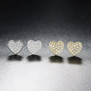 Detalle de pendientes de botón con forma de corazón en oro y plata con circonitas pavé