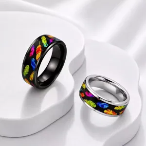 Detailansicht der Regenbogenfeder-Muster auf schwarzen und silbernen Edelstahlringen.