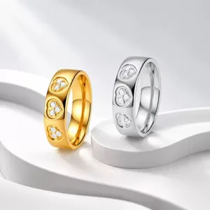 Nahaufnahme von gold- und silberfarbenen Edelstahlringen mit herzförmigen Diamanten