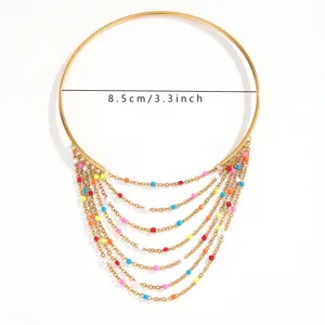 Dettaglio del bracciale da braccio dorato boho con catene a nappa e perline, 8,5 cm diametro.