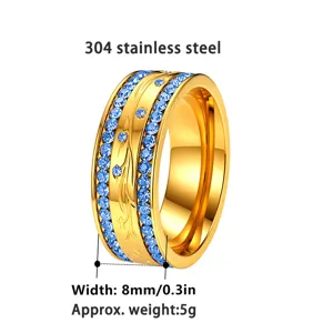 Detailansicht eines goldfarbenen Edelstahlrings mit blauen Strasssteinen und Gravur