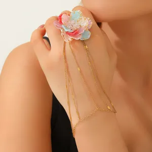 Primer plano de una pulsera anillo vintage con flor 3D de colores en la mano femenina