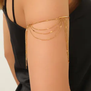 Primo piano del bracciale bohémien dorato a più strati con nappe indossato da una modella