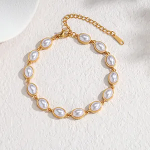 Elégant bracelet en acier titane plaqué or avec inserts en perles blanches ovales.