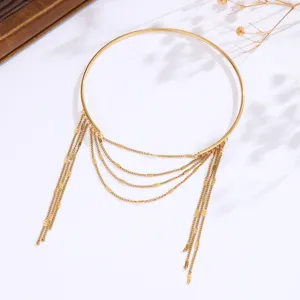 Dettaglio di bracciale da braccio aperto bohémien con nappe multistrato in oro.