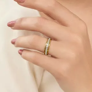 Nahaufnahme eines drehbaren Rings aus Edelstahl mit quadratischen Kristallen auf einem Finger