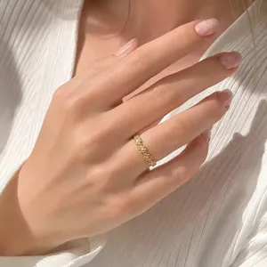 Nahaufnahme eines filigranen goldfarbenen Blumenrings mit funkelnden Diamanten an der Hand
