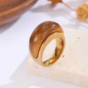 Detailansicht eines Vintage-Bernsteinharzrings mit poliertem goldenem Edelstahlband