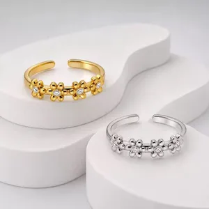 Nahaufnahme von eleganten Gänseblümchenringen aus Edelstahl in Gold und Silber mit CZ