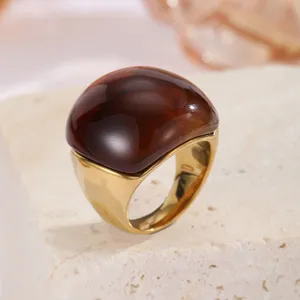 Nahaufnahme eines Vintage-Rings aus goldenem Edelstahl mit einem großen bernsteinfarbenen Stein