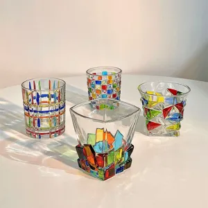 Vista dettagliata di tazze da whisky in vetro dipinto colorato, design artistico per casa e bar.