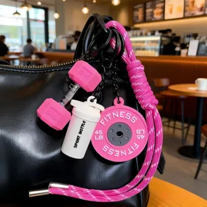Fitness bag charm detail featuring pink dumbbell and shaker bottle keychain accessories.