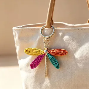 Dettaglio in primo piano del ciondolo per borsa a libellula intrecciato colorato in borsa.