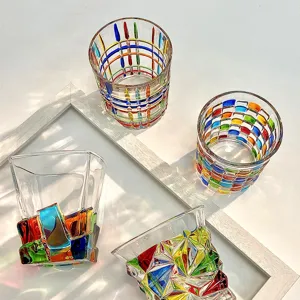 Vista dettagliata di bicchieri colorati dipinti a mano con motivi geometrici e basi uniche.