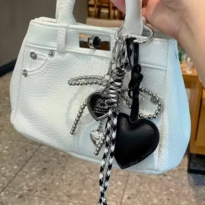 White textured leather mini handbag with chic heart charms and stylish beaded chains.