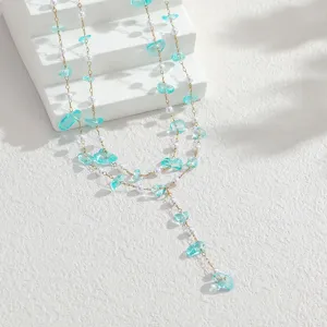 Detailed macro view of lake blue crushed stone and pearl double-layer tassel necklace