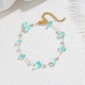 Detailed view of lake blue crushed stone and white pearl beaded bracelet in gold tone
