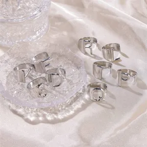 Elegante Alphabet-Ringe aus Silberstahl auf luxuriösem Satinstoff präsentiert