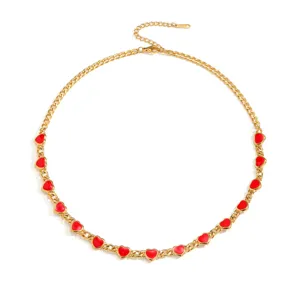Collana in acciaio inossidabile dorato con ciondoli a cuore in smalto rosso.