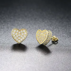 Primer plano de pendientes de corazón dorados con circonitas cúbicas brillantes