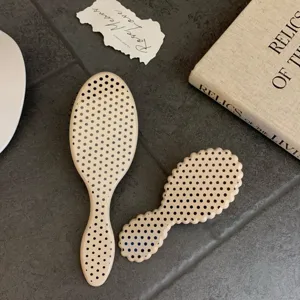 Detailed view of a premium cream polka dot hairbrush set with a vintage prop background