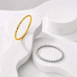 Detailansicht minimalistischer Edelstahlringe mit strukturierter Oberfläche in Gold und Silber.