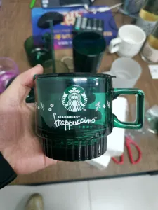 Green glass coffee mug with handle and lid, stylish drinkware for home and office use.
