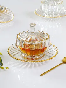 Detailansicht einer klaren Glas-Lotus-Schüssel mit Deckel, Untertasse und goldenen Rändern.